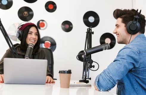 Radio co-hosts talking to each other in studio building brand  awareness and engaging with their audience