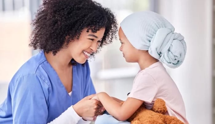 Nurse and child in St. Jude's children's hospital holding hands thanks to donations made to help child around the world