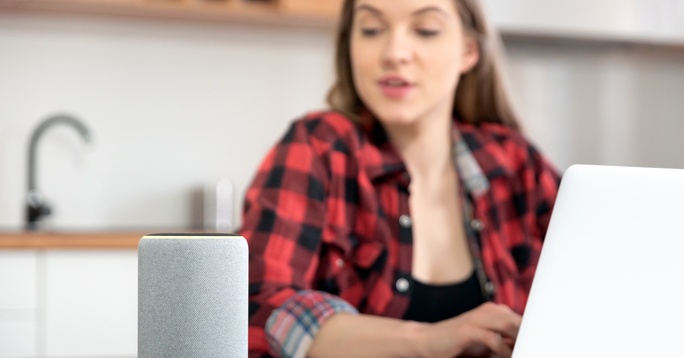 Prospect typing on a laptop and talking into SMART speaker